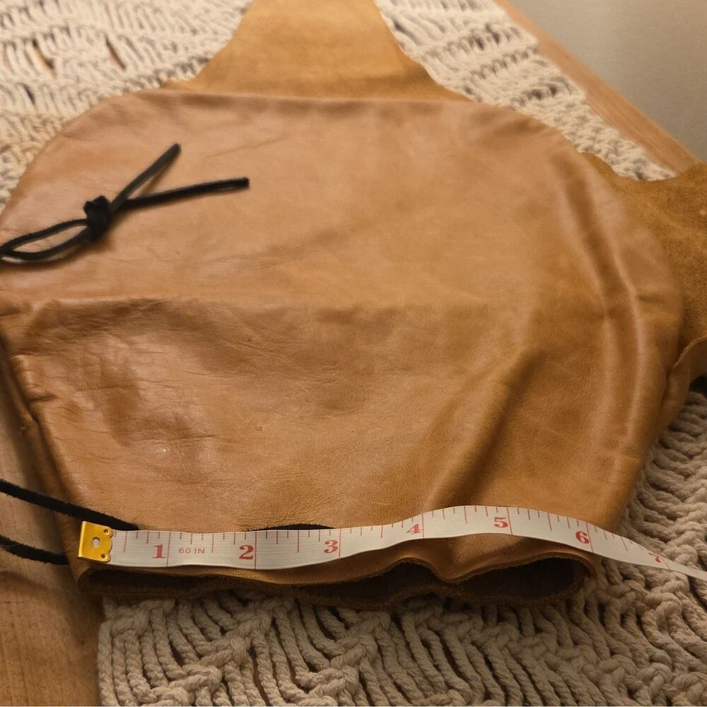 Handcrafted tan leather drawstring pouch featuring a soft fur pom-pom